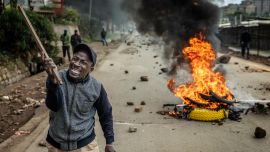 Un manifestante reacciona en una carretera bloqueada con una barricada en llamas y piedras para impedir el paso del tráfico durante una huelga nacional de transporte por el aumento del precio del combustible en Nairobi. El transporte público quedó prácticamente paralizado y los manifestantes bloquearon carreteras en Kenia, tras una huelga convocada por el aumento del precio del combustible provocado por la guerra en Oriente Medio.