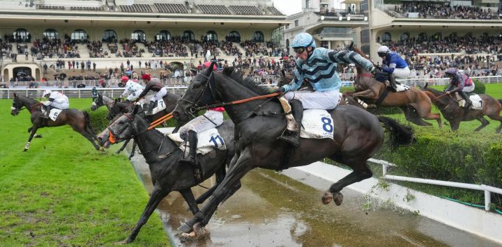 El jinete británico James Revely, montando a "Kolocico", salta un obstáculo de agua durante la 148ª edición de la carrera de obstáculos "Grand Steeple-Chase de Paris" en el Hipódromo de Auteuil, en París.