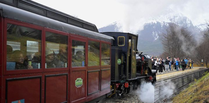 Turistas viajan en el Tren del Fin del Mundo, originalmente construido como línea de carga para servir a la prisión de Ushuaia, principalmente para transportar madera, con destino al Parque Nacional Tierra del Fuego en Ushuaia, Argentina. Ushuaia es la capital de la provincia argentina de Tierra del Fuego. Se ubica en la costa sur de la isla de Tierra del Fuego, rodeada de montañas y con vistas al Canal Beagle, a unos 3040 kilómetros de Buenos Aires.