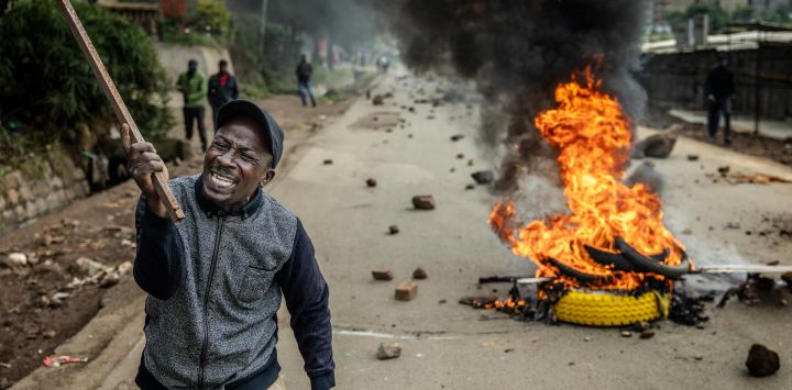 Un manifestante reacciona en una carretera bloqueada con una barricada en llamas y piedras para impedir el paso del tráfico durante una huelga nacional de transporte por el aumento del precio del combustible en Nairobi. El transporte público quedó prácticamente paralizado y los manifestantes bloquearon carreteras en Kenia, tras una huelga convocada por el aumento del precio del combustible provocado por la guerra en Oriente Medio.
