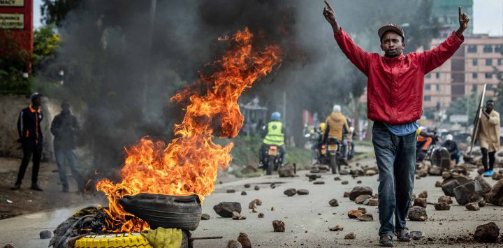 Un manifestante reacciona junto a una barricada en llamas en una carretera bloqueada con piedras para impedir el paso del tráfico durante una huelga nacional de transporte por el aumento del precio del combustible en Nairobi. El transporte público quedó prácticamente paralizado y los manifestantes bloquearon carreteras en Kenia tras una huelga convocada por el aumento del precio del combustible provocado por la guerra en Oriente Medio.