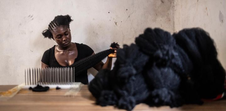 Una trabajadora coloca extensiones de cabello en un taller dentro del barrio chino de Ojota, en Lagos, Nigeria.