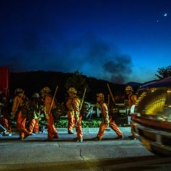 Bomberos reclusos regresan a su camión de bomberos tras combatir el incendio Sandy en Simi Valley, California. Un incendio forestal se desató en los suburbios de Los Ángeles, propagándose rápidamente y obligando a las autoridades a emitir órdenes de evacuación para miles de residentes. El incendio, denominado Sandy, comenzó a última hora de la mañana en Simi Valley, una ciudad de aproximadamente 125 000 habitantes ubicada a unos 60 kilómetros al noroeste del centro de Los Ángeles. | Foto:APU GOMES / AFP