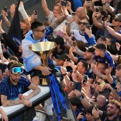 El delantero argentino del Inter de Milán, Lautaro Martínez y sus compañeros desfilan en un micro descapotable para celebrar su 21.º Scudetto con los aficionados a las afueras del estadio San Siro, tras el partido de fútbol de la Serie A italiana entre el Inter de Milán y el Hellas Verona en Milán. | Foto:Luca Bruno / POOL / AFP