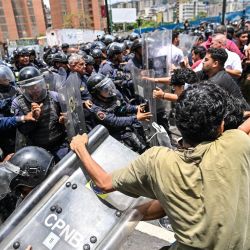 Estudiantes de la Universidad Central de Venezuela (UCV) se enfrentan a agentes de la Policía Nacional Bolivariana (PNB) durante una protesta tras la muerte de Carmen Navas, madre del difunto preso político Víctor Quero Navas, en Caracas. La madre del preso político venezolano Víctor Hugo Quero Navas falleció a los 81 años, pocos días después de confirmar la muerte de su hijo bajo custodia estatal, según informaron sus familiares a la AFP. | Foto:JUAN BARRETO / AFP