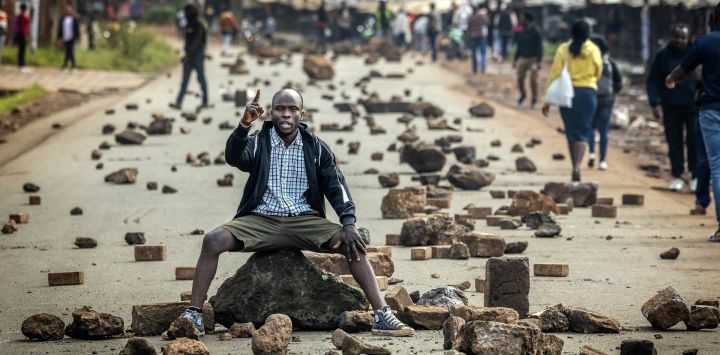 Un manifestante corea consignas antigubernamentales en una carretera bloqueada con piedras para impedir el paso del tráfico durante una huelga nacional de transporte por el aumento del precio del combustible en Nairobi. El transporte público quedó prácticamente paralizado y los manifestantes bloquearon carreteras en Kenia tras una huelga convocada por el aumento del precio del combustible provocado por la guerra en Oriente Medio.