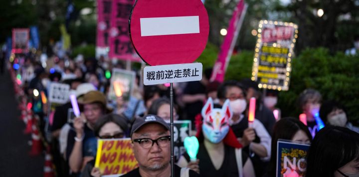 Imagen de personas sosteniendo pancartas mientras participan en una protesta frente al edificio de la Dieta Nacional, en Tokio, Japón.