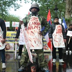 Miembros de la comunidad tamil en Francia, ataviados con delantales que simulaban sangre y llevaban la inscripción "Ejército de Sri Lanka", participaron en una marcha de protesta en París, exigiendo que Sri Lanka reconociera lo que ellos denominan el genocidio tamil. | Foto:ALAIN JOCARD / AFP
