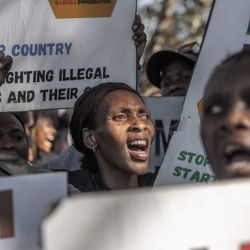 Miembros de “March and March” portan pancartas y corean consignas antimigrantes durante una marcha de protesta en Durban. El grupo exige medidas más contundentes contra la inmigración ilegal y la deportación de extranjeros indocumentados. La protesta se produce en medio de la creciente preocupación pública por el control fronterizo, la aplicación de la ley y la política nacional del gobierno. | Foto:RAJESH JANTILAL / AFP