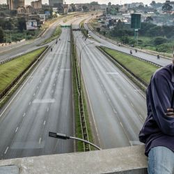 Un trabajador varado permanece sentado en un puente con vistas a la autopista Thika, una de las principales vías de Kenia, prácticamente vacía, en el segundo día de una huelga nacional de transporte por el aumento del precio del combustible en Nairobi. La huelga de transporte en Kenia, desencadenada por la guerra en Oriente Medio, paralizó el país por segundo día consecutivo, tras la muerte de cuatro personas y los numerosos heridos del día anterior. | Foto:LUIS TATO / AFP
