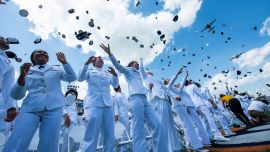 Oficiales recién ascendidos lanzan sus birretes al aire durante el sobrevuelo de la 145.ª ceremonia de graduación de la Guardia Costera de Estados Unidos en New London, Connecticut. El presidente estadounidense Donald Trump pronunció el discurso de graduación.