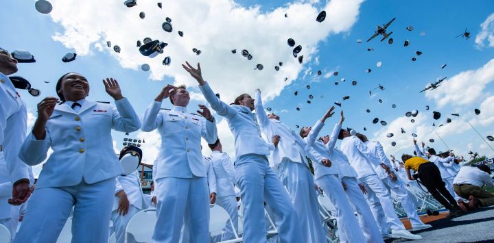 Oficiales recién ascendidos lanzan sus birretes al aire durante el sobrevuelo de la 145.ª ceremonia de graduación de la Guardia Costera de Estados Unidos en New London, Connecticut. El presidente estadounidense Donald Trump pronunció el discurso de graduación.