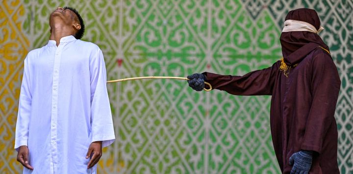 Un hombre recibe 100 latigazos de un miembro de la policía islámica durante una flagelación pública en Banda Aceh, Indonesia, tras ser declarado culpable de violar la ley islámica de Aceh que prohíbe las relaciones sexuales fuera del matrimonio.