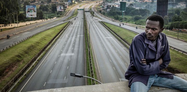 Un trabajador varado permanece sentado en un puente con vistas a la autopista Thika, una de las principales vías de Kenia, prácticamente vacía, en el segundo día de una huelga nacional de transporte por el aumento del precio del combustible en Nairobi. La huelga de transporte en Kenia, desencadenada por la guerra en Oriente Medio, paralizó el país por segundo día consecutivo, tras la muerte de cuatro personas y los numerosos heridos del día anterior.