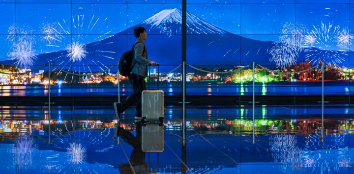 Un viajero pasa junto a una imagen del Monte Fuji en la terminal de llegadas del aeropuerto de Haneda en Tokio, Japón.