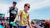 Kyle Busch, izquierda, y su hijo, saludan a los fanáticos previo a una carrera de la NASCAR Cup Series en Talladega Superspeedway, el 23 de abril de 2023, en Talladega, Alabama 