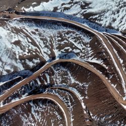 This view shows snow-covered peaks of the Andes mountain range with a road built for mineral exploration in Calingasta, San Juan province, Argentina, on April 22, 2026. 