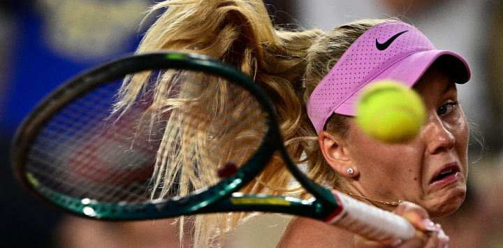 La francesa Ksenia Efremova devuelve un golpe de derecha a la rumana Sorana Cirstea durante su partido individual femenino en la primera jornada del torneo de tenis Roland Garros, disputado en la pista Suzanne-Lenglen del complejo Roland-Garros de París.