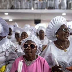 Los fieles bailan mientras sostienen ofrendas de acción de gracias durante un servicio religioso en la sede internacional de la Iglesia Celestial de Cristo en el barrio de Ketu, en Lagos, Nigeria. | Foto:OLYMPIA DE MAISMONT / AFP