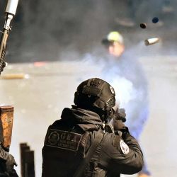 Un policía antidisturbios boliviano dispara contra manifestantes durante una protesta contra el presidente Rodrigo Paz en La Paz. La presidencia de Paz se ha visto sacudida por protestas arraigadas, centradas en La Paz, la capital administrativa de Bolivia, que han provocado el bloqueo de carreteras y la consiguiente escasez de alimentos, combustible y medicinas. | Foto:MARVIN RECINOS / AFP
