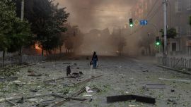 Una mujer camina por una calle llena de humo junto a edificios gravemente dañados tras los ataques rusos en Kiev, en el contexto de la invasión rusa de Ucrania. Un potente ataque con misiles balísticos sacudió Kiev, según informaron las autoridades, hiriendo al menos a cinco personas después de que Moscú amenazara con represalias por los ataques en el este de Ucrania, territorio ocupado por Rusia.