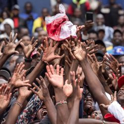 Aficionados kenianos del Arsenal FC se abalanzan por una camiseta del equipo durante un lanzamiento de merchandising organizado por los organizadores de un festival callejero para celebrar el tan esperado campeonato de la Premier League 2025-26 en Nairobi, capital de Kenia. Los 'Gunners' pusieron fin oficialmente a una angustiosa espera de 22 años al coronarse campeones de la Premier League tras su último partido de la temporada contra el Crystal Palace. | Foto:TONY KARUMBA / AFP
