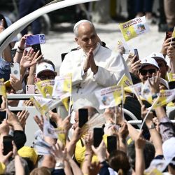 El papa León XIV saluda a la multitud desde el papamóvil en la Piazza Nicola Calipari durante una visita pastoral a la comunidad de la «Tierra de los Fuegos». La Tierra de los Fuegos (terra dei fuochi) es una zona del sur de Italia, en la región de Campania, donde, desde finales de los años 80, el crimen organizado (Camorra) ha vertido sistemáticamente residuos tóxicos, causando delitos medioambientales relacionados con la basura. Acerra y sus alrededores presentan tasas de cáncer superiores a la media, vinculadas al vertido, la quema y el enterramiento de residuos tóxicos. | Foto:Filippo Monteforte / AFP
