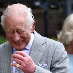 El rey Carlos III de Gran Bretaña ríe mientras él y la reina Camila de Gran Bretaña saludan al personal durante una visita a The Warehouse, en Newtownards, Irlanda del Norte, en el último día de una visita real de tres días a Irlanda del Norte. Ubicado en un antiguo pub, The Warehouse se ha transformado en un centro comunitario animado y acogedor, que ofrece apoyo vital a través de alimentos gratuitos, comidas calientes para llevar, talleres de capacitación y acceso a ropa y artículos básicos para el hogar gratuitos. | Foto:HENRY NICHOLLS / POOL / AFP