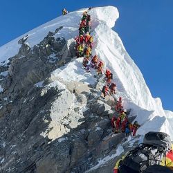Esta fotografía muestra a montañeros alineados escalando una pendiente durante su ascenso desde el Escalón Hillary hasta la cima del Monte Everest en Nepal. | Foto:Furte Sherpa / AFP