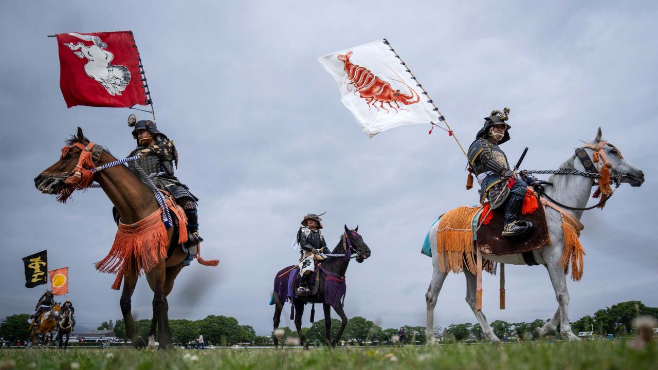 Jinetes ataviados con armadura samurái llegan al campo de Hibarigahara durante el festival Soma Nomaoi en Minamisoma, prefectura de Fukushima. El festival Soma Nomaoi, con siglos de antigüedad, reúne a cientos de participantes a caballo que recrean ejercicios militares de la época samurái, preservando tradiciones que se remontan a más de un milenio. | Foto:Yuichi Yamazaki / AFP