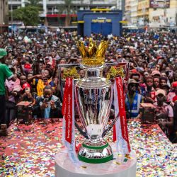 Aficionados kenianos del Arsenal FC se congregan en una fiesta callejera con una réplica del trofeo en exhibición para celebrar el tan ansiado campeonato de la Premier League 2025-26 del equipo en Nairobi, capital de Kenia. Los 'Gunners' pusieron fin oficialmente a una agonizante espera de 22 años al coronarse campeones de la Premier League tras su último partido de la temporada contra el Crystal Palace. | Foto:TONY KARUMBA / AFP
