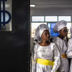 Los fieles permanecen de pie cerca de la puerta de salida durante un servicio religioso en la sede internacional de la Iglesia Celestial de Cristo en el barrio de Ketu, en Lagos, Nigeria. | Foto:OLYMPIA DE MAISMONT / AFP