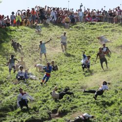 Los participantes de la segunda carrera masculina ruedan cuesta abajo persiguiendo un queso Double Gloucester redondo durante la competición anual de rodar quesos de Cooper's Hill, cerca del pueblo de Brockworth, Gloucester, en el oeste de Inglaterra. La competición anual de rodar quesos de Cooper's Hill consiste en que los participantes persigan un queso Double Gloucester de ocho libras (3,63 kg) cuesta abajo por una pendiente pronunciada. | Foto:Adrian Dennis / AFP