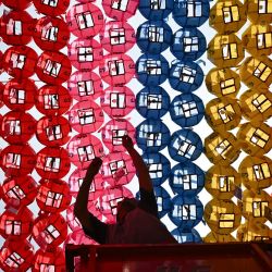 Un hombre coloca tarjetas con los deseos de los fieles budistas en faroles de loto expuestos en el templo Jogye tras una ceremonia para celebrar el cumpleaños de Buda en Seúl, Corea del Sur. | Foto:PEDRO PARDO / AFP