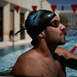 Un nadador se hidrata al borde de una piscina municipal al aire libre mientras una ola de calor excepcionalmente temprana eleva las temperaturas por encima de los 37 °C en Burdeos, al suroeste de Francia. Francia está sufriendo una ola de calor excepcionalmente temprana, y Météo-France ha emitido alertas naranjas por calor en varios departamentos; es la primera vez que se activan estas alertas tan pronto en el año. | Foto:Philippe López / AFP