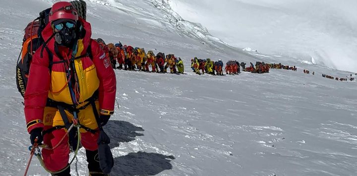 Esta fotografía muestra a montañeros alineados escalando una ladera durante su ascenso a la cima del Monte Everest en Nepal.