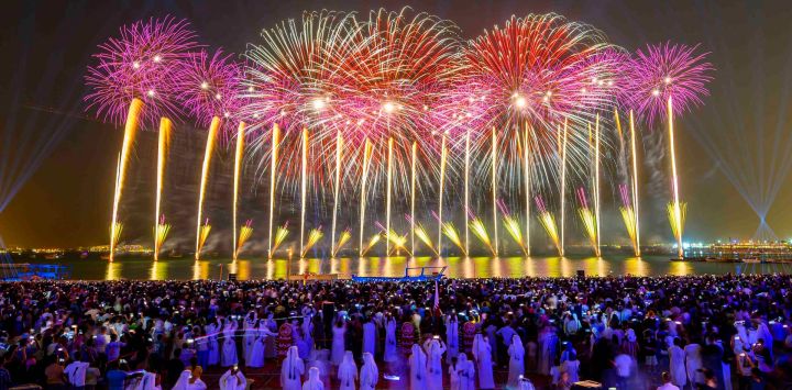Imagen de fuegos artificiales durante las celebraciones del Eid al-Adha iluminando el cielo sobre la Aldea Cultural Katara, en Doha, Qatar.