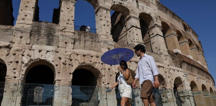 Imagen de turistas caminando frente al Coliseo durante una ola de calor, en Roma, Italia. Europa sufre una ola de calor sin precedentes de principios de temporada, provocada por una potente "cúpula de calor" que ha batido récords de temperatura en varios países, generando preocupación por la salud pública y ha intensificado los llamamientos a una acción climática más rápida.