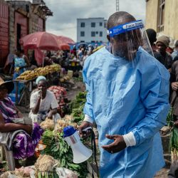 El primo Kasumbo, presidente de la comunidad U Report Goma, vestido con equipo de protección, realiza actividades de sensibilización entre comerciantes junto a jóvenes miembros del grupo “U Report Goma”, quienes continúan sus labores de concienciación en el mercado de Alanine utilizando megáfonos y grupos de discusión como parte de las medidas de prevención y sensibilización sobre el ébola en Goma. El jefe de salud de la ONU estuvo en la República Democrática del Congo, donde las autoridades luchan por contener la propagación de un brote mortal de ébola, pero se confirmó la recuperación de un paciente, el primero desde que comenzó la crisis. | Foto:Jospin Mwisha / AFP