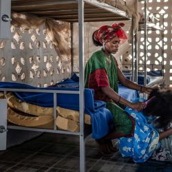 Genet Gebremeskel Gebremariam, de 30 años, migrante de Tigray que espera regresar a Etiopía, peina a otro migrante en su dormitorio en un centro de asistencia de la Organización Internacional para las Migraciones (OIM) en Obock. En Yibuti, decenas de hombres emprenden la larga travesía de regreso a casa tras el fracaso de su intento de cruzar una de las rutas migratorias más peligrosas del mundo, desde África hasta el Golfo Pérsico. Decenas de miles de migrantes se aventuran cada año por la llamada Ruta Oriental, la mayoría partiendo de Yibuti, situada a tan solo 30 km de Yemen en su punto más cercano. Más de 900 personas murieron o desaparecieron a lo largo de esta ruta en 2025, el año más mortífero registrado hasta la fecha, según la Organización Internacional para las Migraciones (OIM) de la ONU. | Foto:LUIS TATO / AFP