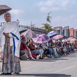Los votantes se protegen del sol con paraguas mientras hacen fila para emitir su voto frente al centro de votación de Beshale Katla en Addis Abeba, durante las elecciones parlamentarias etíopes de 2026. Los etíopes comenzaron a votar en las elecciones parlamentarias, y se espera que gane el partido del primer ministro saliente, Abiy Ahmed, quien se postula para un nuevo mandato. Alrededor de 50 millones de personas tienen derecho a votar en las elecciones para elegir a los miembros del parlamento, quienes a su vez elegirán al primer ministro. | Foto:Marco Simoncelli / AFP