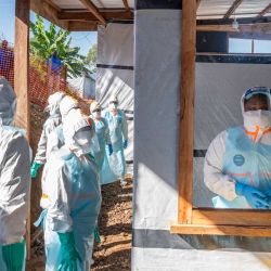 Personal sanitario se encuentra en un nuevo centro de tratamiento del ébola durante la visita de Tedros Adhanom Ghebreyesus, Director General de la Organización Mundial de la Salud (OMS), a Bunia, en el noreste de la República Democrática del Congo. El director general de la OMS había anunciado previamente su visita a Bunia, capital de la provincia de Ituri, para "ayudar" y "escuchar" a las personas que se enfrentan a los peores efectos del brote. Esta fiebre hemorrágica altamente contagiosa ya está presente en tres provincias del este de la RDC y en la vecina Uganda, donde se han registrado nueve infecciones confirmadas, incluyendo una muerte. Se han registrado al menos 1.077 casos sospechosos de ébola en la RDC desde que se declaró el brote el 15 de mayo, incluyendo 246 muertes, según informaron los Centros Africanos para el Control y la Prevención de Enfermedades. | Foto:GLODY MURHABAZI / AFP