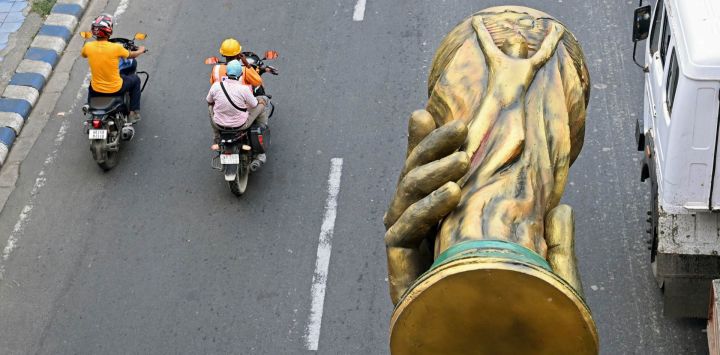 Trabajadores trasladan una estatua del futbolista argentino Lionel Messi, que incluye una réplica del trofeo de la Copa Mundial de la FIFA, tras su retirada para ser reinstalada en un lugar más seguro en Calcuta, India.