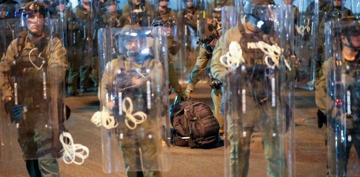 Un manifestante (no visible en la imagen) es arrestado mientras la policía estatal de Nueva Jersey monta guardia cerca de Delaney Hall, un centro de detención del Servicio de Inmigración y Control de Aduanas (ICE), durante el toque de queda en Newark, Nueva Jersey.