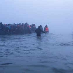 Traficantes de personas ayudan a migrantes a abordar una embarcación en un intento por cruzar el Canal de la Mancha frente a la playa de Gravelines, en el norte de Francia. | Foto:SAMEER Al-DOUMY / AFP
