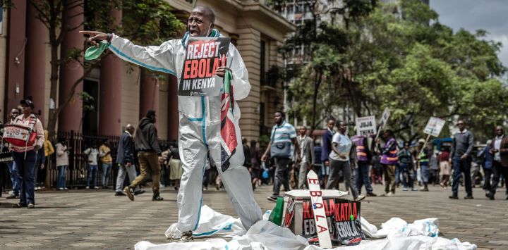 Un activista grita consignas a los transeúntes junto a un ataúd simbólico durante una protesta contra un centro de cuarentena para el ébola construido por Estados Unidos, cuya apertura estaba prevista en la base aérea de Laikipia, en Kenia, en el centro de Nairobi. El presidente de Kenia defendió la apertura de un centro de cuarentena para ciudadanos estadounidenses después de que un tribunal paralizara el plan y las fuerzas de seguridad lanzaran gases lacrimógenos contra los manifestantes que temían que el virus mortal se propagara en el país. Según funcionarios estadounidenses, las instalaciones construidas por Estados Unidos en la base aérea de Laikipia debían abrir la semana pasada para poner en cuarentena a los estadounidenses que llegaran de la República Democrática del Congo (RDC), que lucha contra un importante brote de ébola.