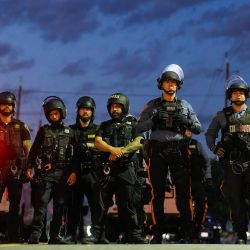 Agentes de la policía estatal de Nueva Jersey montan guardia cerca de Delaney Hall, centro de detención del Servicio de Inmigración y Control de Aduanas (ICE), minutos antes del inicio del toque de queda, en Newark, Nueva Jersey. Las autoridades estatales de Nueva Jersey anunciaron que se harían cargo de la seguridad en las inmediaciones del centro de detención de inmigrantes tras los enfrentamientos entre agentes del ICE y manifestantes indignados por las condiciones de los detenidos. Los disturbios han derivado en arrestos, mientras que la postura intransigente del gobierno del presidente estadounidense Donald Trump en materia de política migratoria sigue generando oposición, incluso por parte de autoridades de estados gobernados por demócratas. | Foto:EDUARDO MUNOZ / AFP