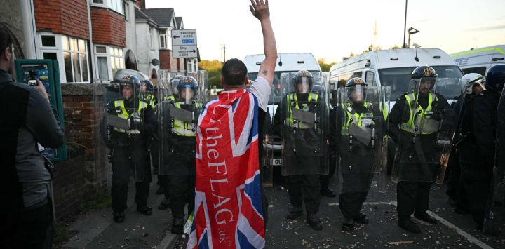 Manifestantes protestaron junto a agentes de policía cerca de la comisaría de Portswood en Southampton, al sur de Inglaterra, en respuesta a la actuación policial en la detención de la víctima Henry Nowak, tras la condena de su asesino, Vickrum Digwa.