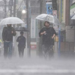 En Kawasaki, prefectura de Kanagawa, Japón, la gente se desplaza bajo la intensa lluvia provocada por la fuerte tormenta tropical Jangmi. | Foto:Yuichi Yamazaki / AFP