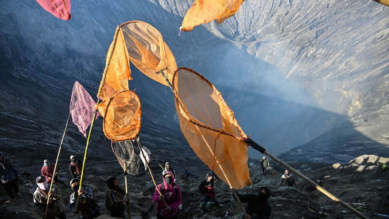 Los aldeanos recogen las ofrendas que los devotos hindúes de la comunidad Tengger arrojan al cráter del monte Bromo durante el festival Yadnya Kasada cerca de Probolinggo, provincia de Java Oriental, Indonesia. | Foto:JUNI KRISWANTO / AFP